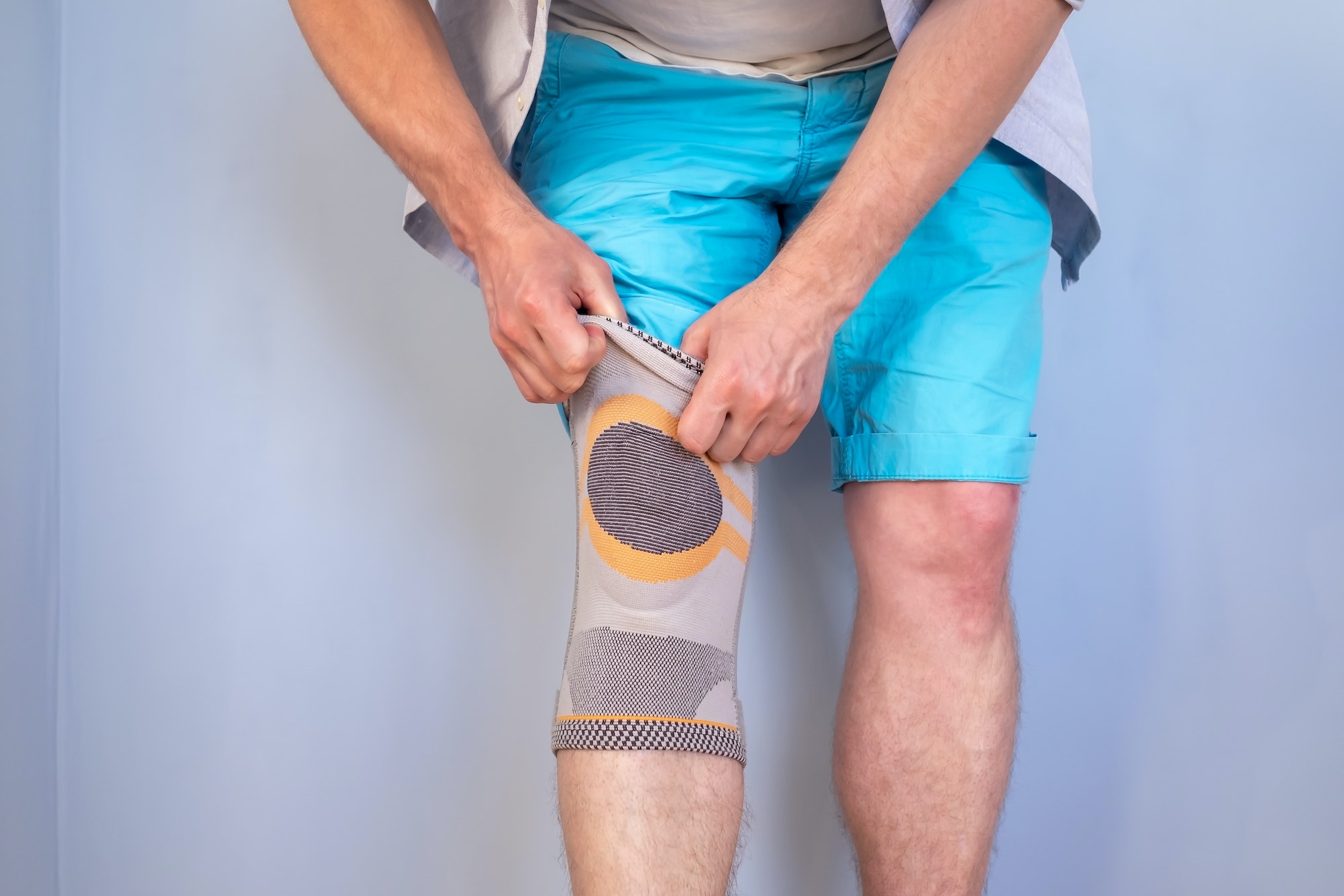 Man puts special stabilizing brace on injured knee joint